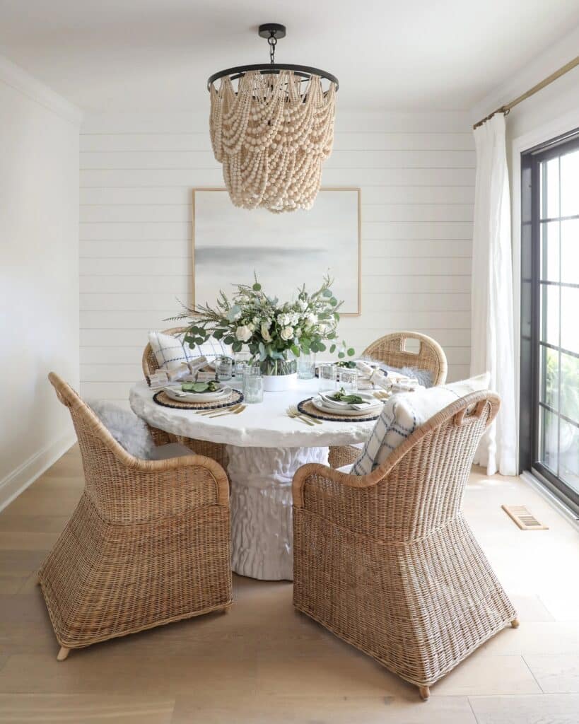 Round white table with wicker chairs and cushion from our Thanksgiving decorating ideas guide.
