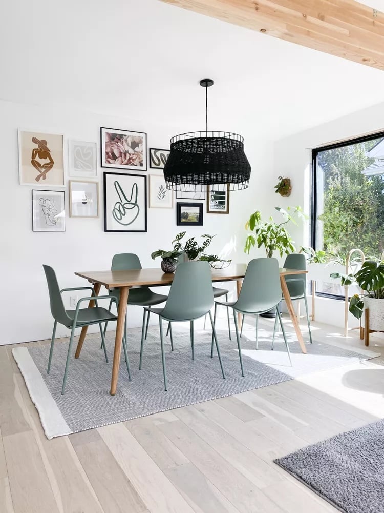 Dining room updates with wood table, teal chairs, and black rattan light fixture.