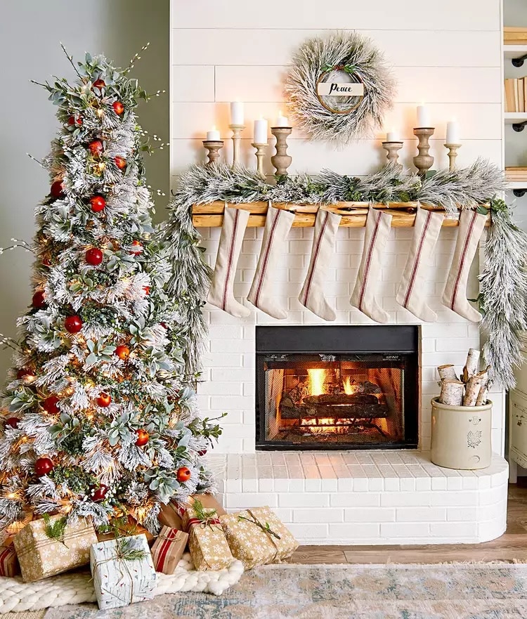 White brick fireplace with Christmas tree and stockings.