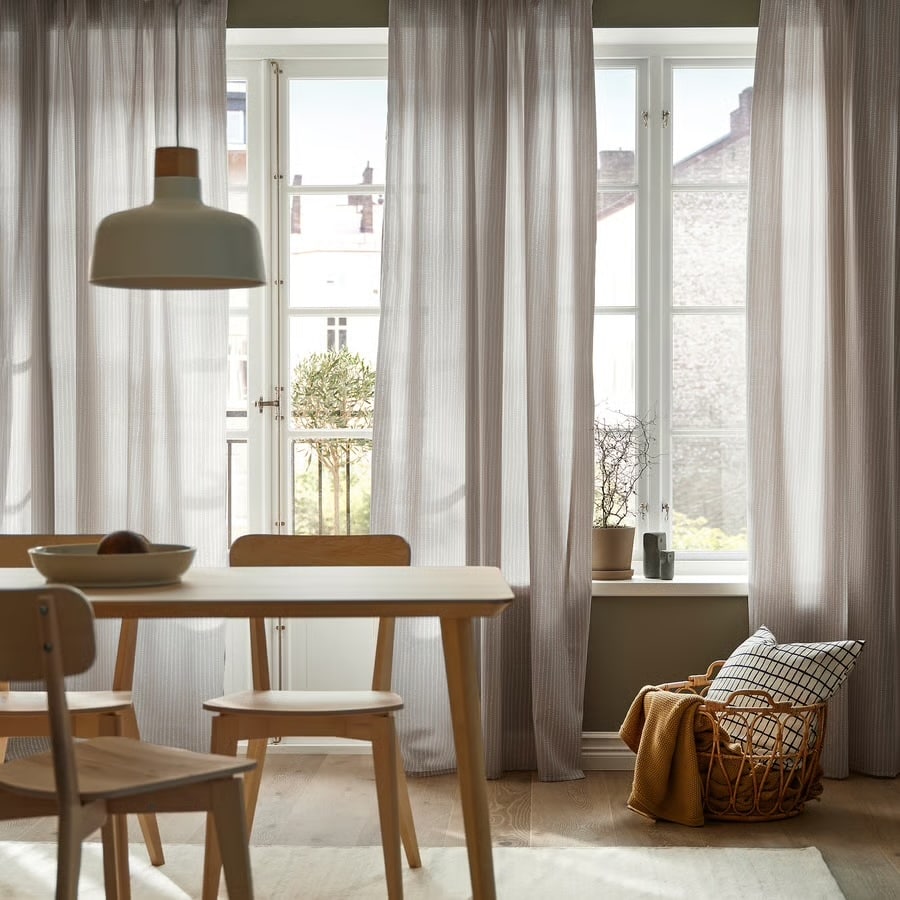 Dining room with sheer curtains from IKEA, pendant light, light wood table and chairs from our design updates guide.