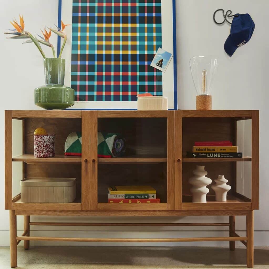 Media center with green vase and other decor.