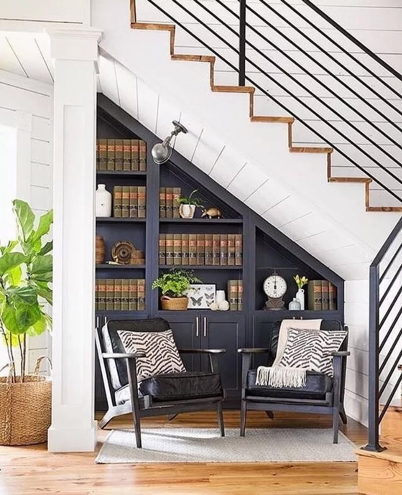 Black built in shelving bookcases under the stairway.