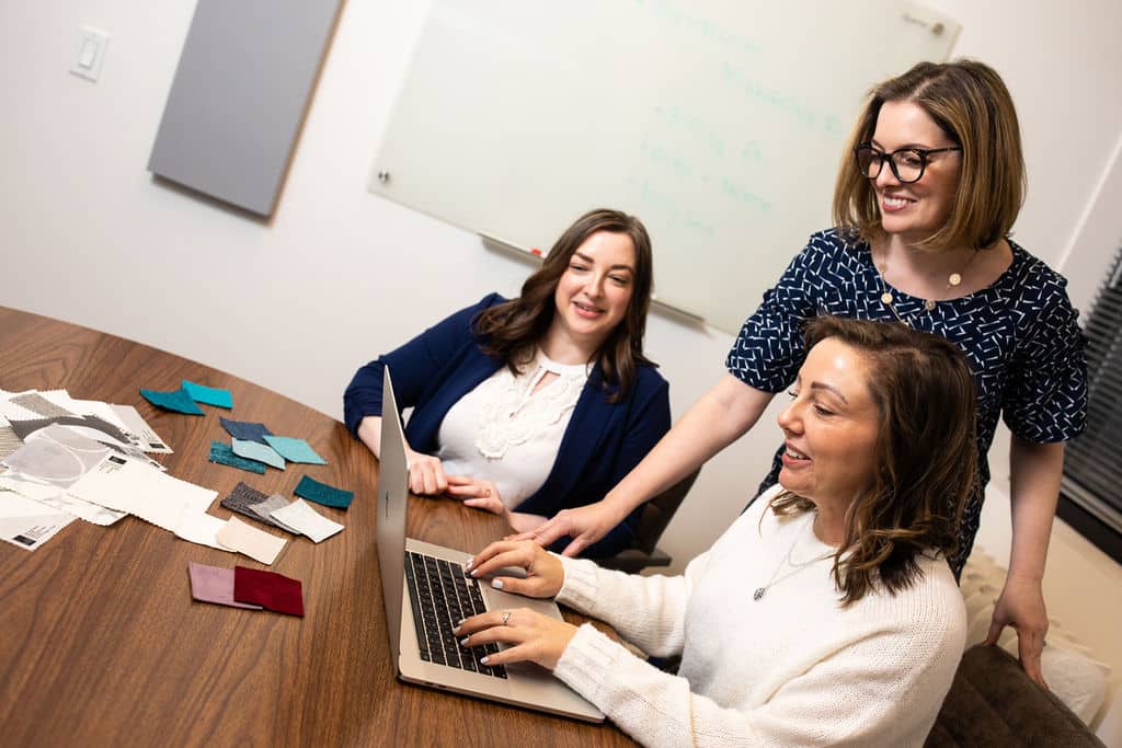 Interior designers in NYC discussing a clients project in a conference room.