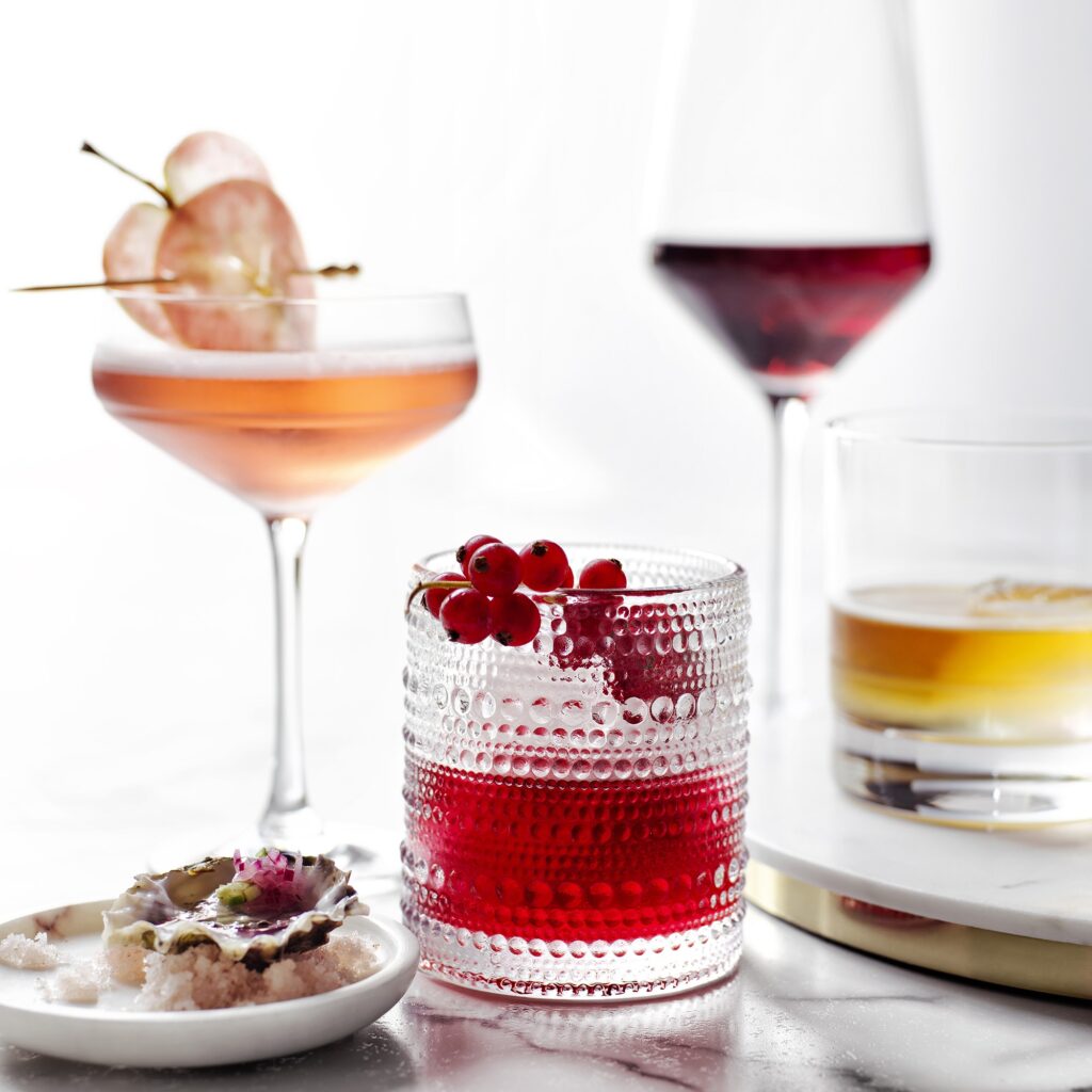 Tumbler with red liquid drink and cherries on the rim from our affordable kitchenware and serveware guide.