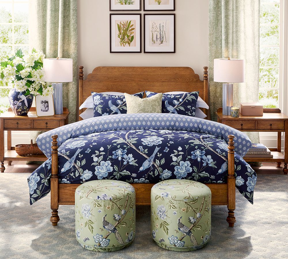 Pottery Barn ood bed frame with blue devet cover and green and blue ottomans at the foot of the bed.