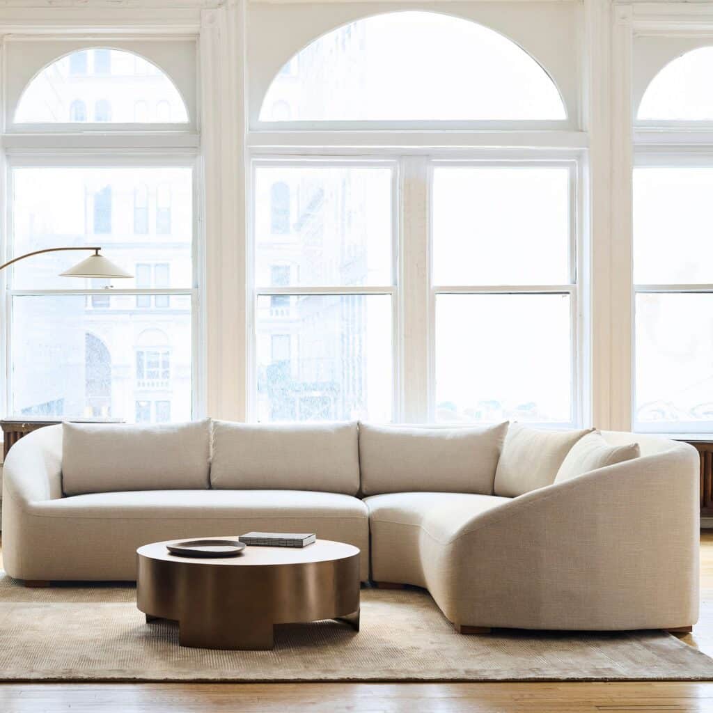 Sectional sofa paired with a round coffee table that maintains balanced scale and circulation.