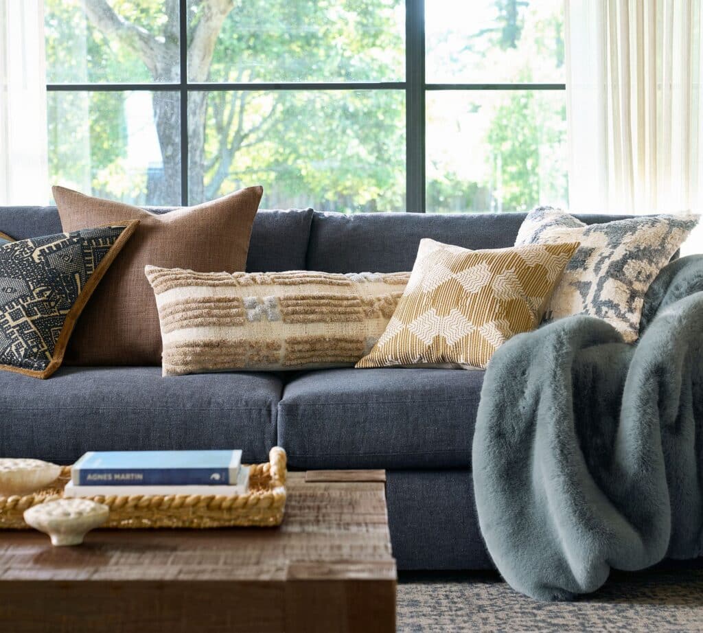 Ikat patterned fabric used in pillows within a layered living room design.