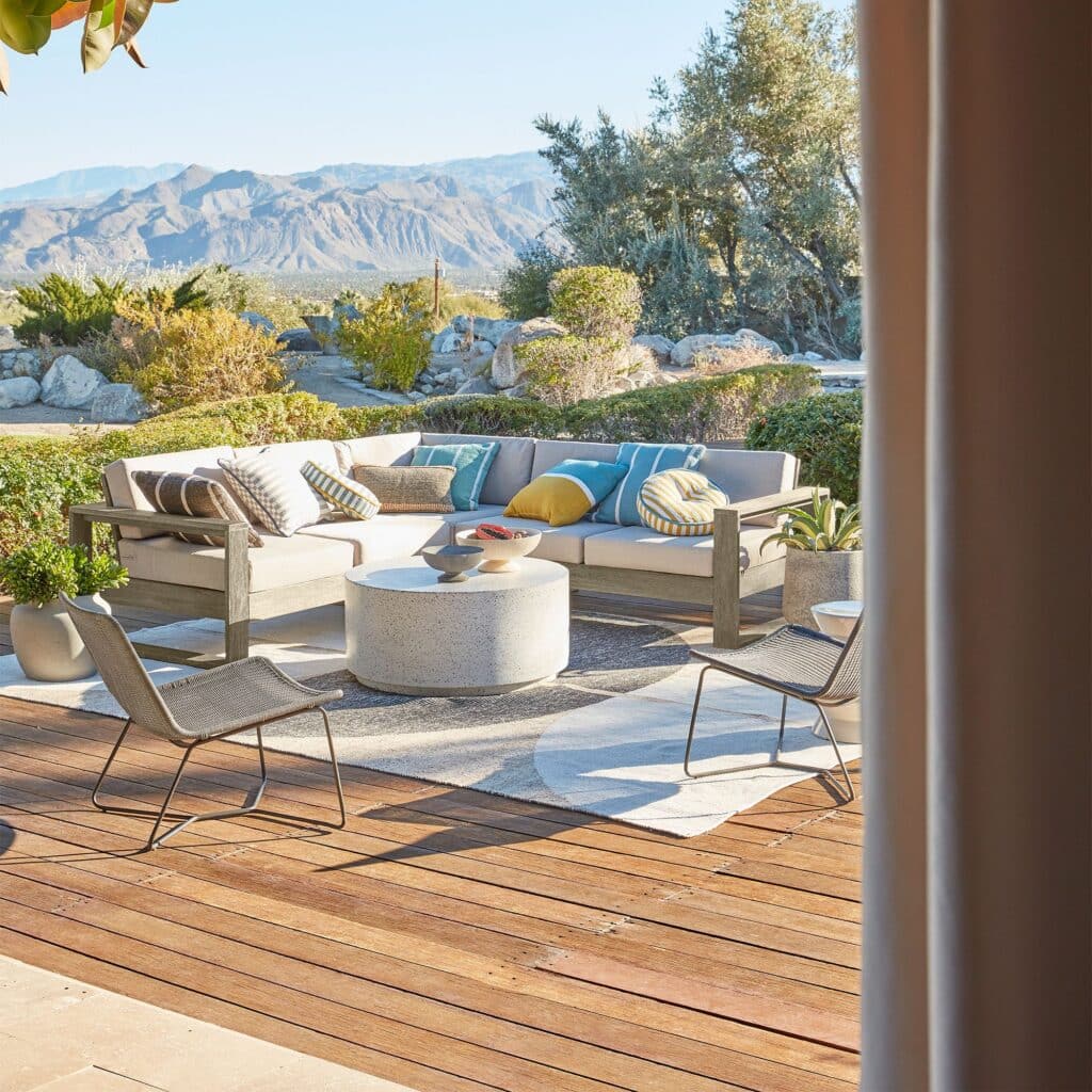 Outdoor seating area with weather-resistant sofa and chairs on a patio.
