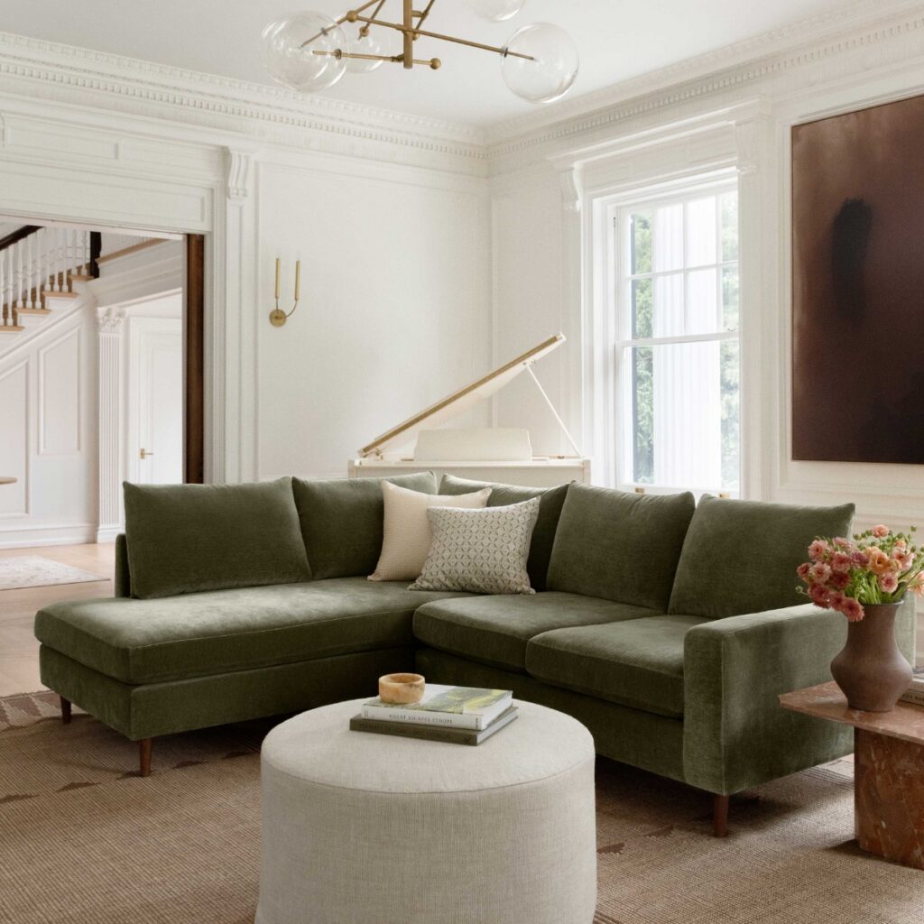 Living room with a jewel-toned velvet sofa paired with neutral furnishings.