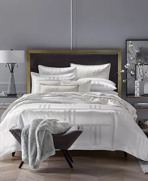 Hotel-style white summer bedding with crisp cotton sheets and structured layering.