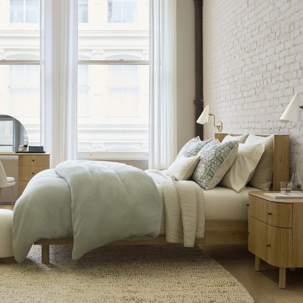 Modern bedroom with cotton gauze summer bedding in light green and ivory tones.