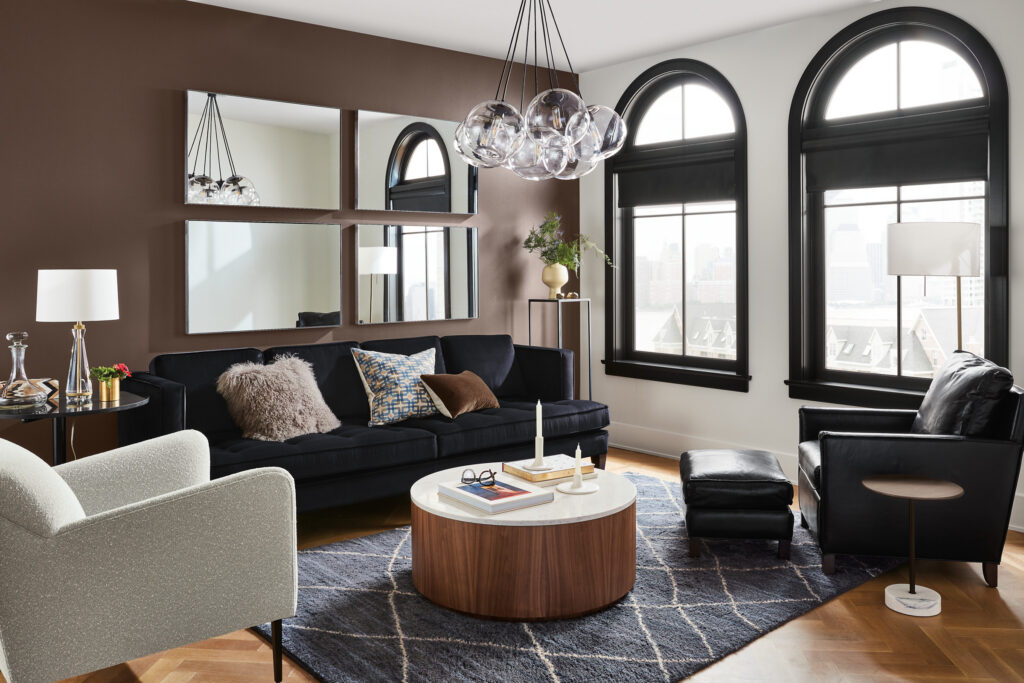 Neutral living room with a sofa, large rug, and table lamp.