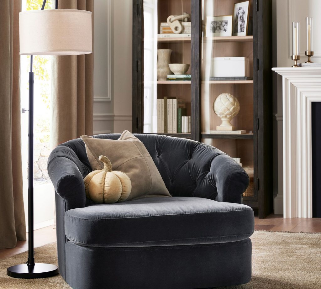 Floor lamp positioned beside an accent chair to provide light for a living room seating area.